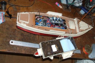 bacchus 6
les entrailles de la chose; comme vous pouvez le constater, c'est plein. En effet, la récupération ne permet de faire le difficile. On fait avec. Le récepteur (découpé sur un récepteur de voiture pour enfants) et le décodeur sont sous la mousse du roof (d'où les fils); ce qu'on voit, ce sont les servos moteurs hand made et les chargeurs. Il suffit de brancher bacchus sur une batterie externe (entre 8 et 20 V) et il se débrouille. On n'arrête pas le progrès
