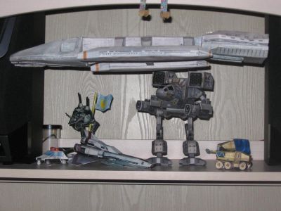 Dans le meuble tÃ©lÃ©
Ici sont prÃ©sent de gauche Ã  droite:
- Voiture de police (Canon)
- Robotech - Zentraedi Battlepod
- Battlestar Galactica (2003) - Viper MK-IV
- Battletech (Mechwarrior) - Mad Cat (Timberwolf)
- Aliens - Surface Seeker (http://aliens.humlak.cz/aliens/aliens_papirove_modely_gb.htm)
