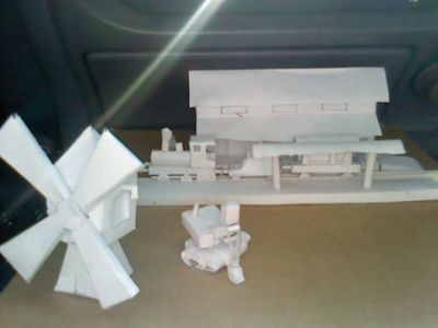 Diorama en cours, une gare, un moulin, et une pelleteuse pour le chantier
